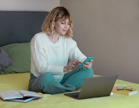 Young woman uses her smartphone for self-investment