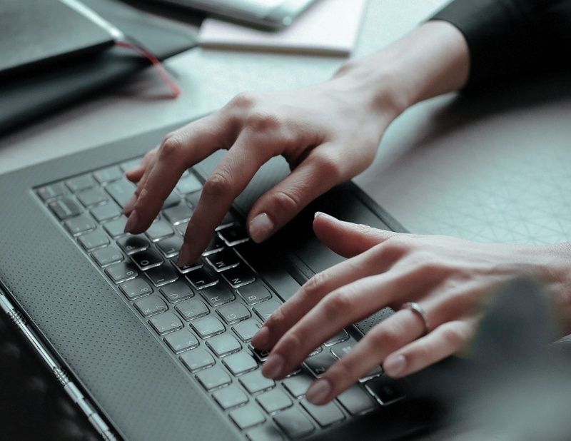 Fingers typing on laptop keyboard