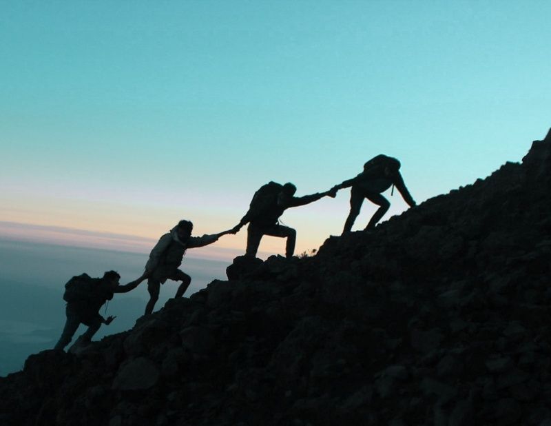 Group of people climbs a mountain